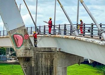 Instalação de cabos de aço é realizada no pilar principal da passarela Joaquim Macedo